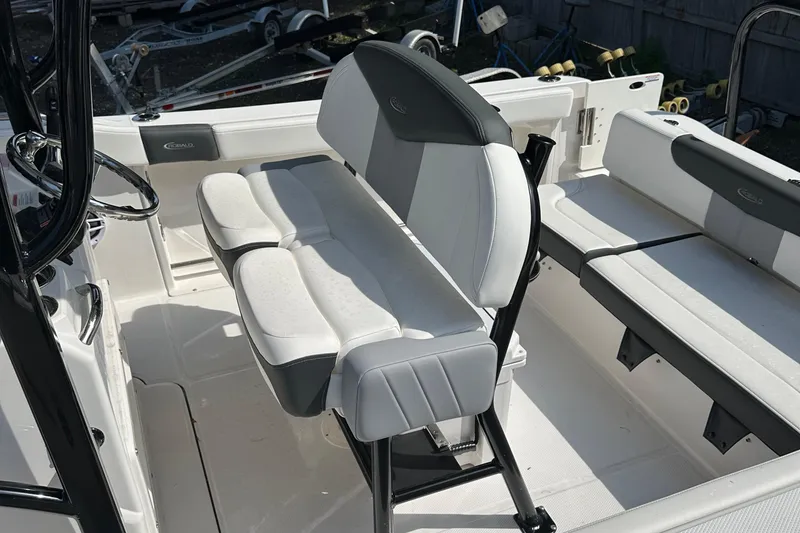 Slide: The Image of 2025 Robalo R222 Explorer boat interior with cushioned seating and steering console. - 6