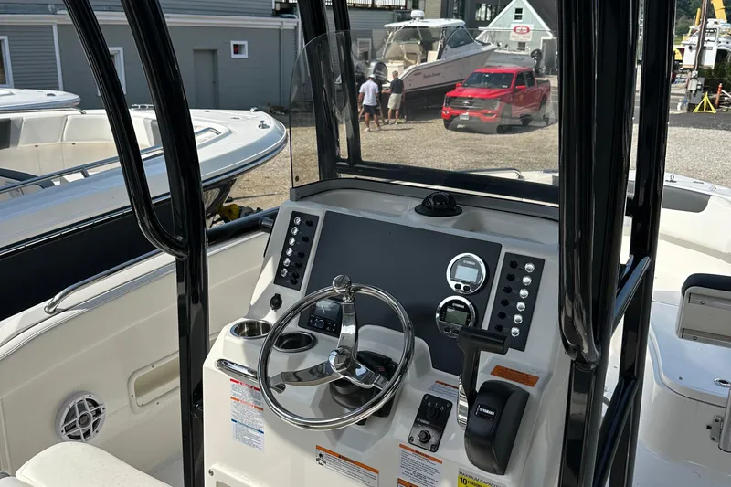 Slide: The Image of 2025 Robalo R222 Explorer boat dashboard with steering wheel and controls. - 7