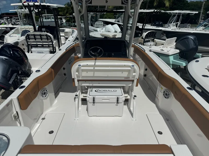 Slide: The Image of 2025 Robalo R250 Center Console boat interior with seating and console, docked among other boats. - 4