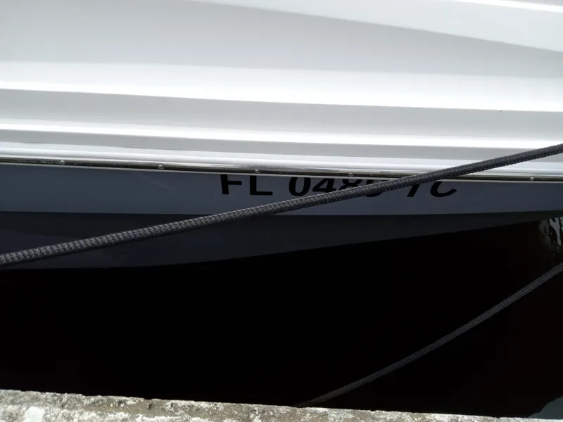 Slide: The Image of 2022 Sea Ray SDX 250 Outboard docked, partial view with registration number visible. - 15