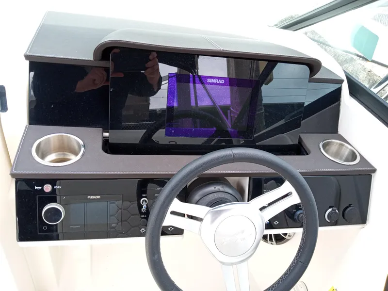 Slide: The Image of 2022 Sea Ray SDX 250 Outboard dashboard with steering wheel and control panel. - 3