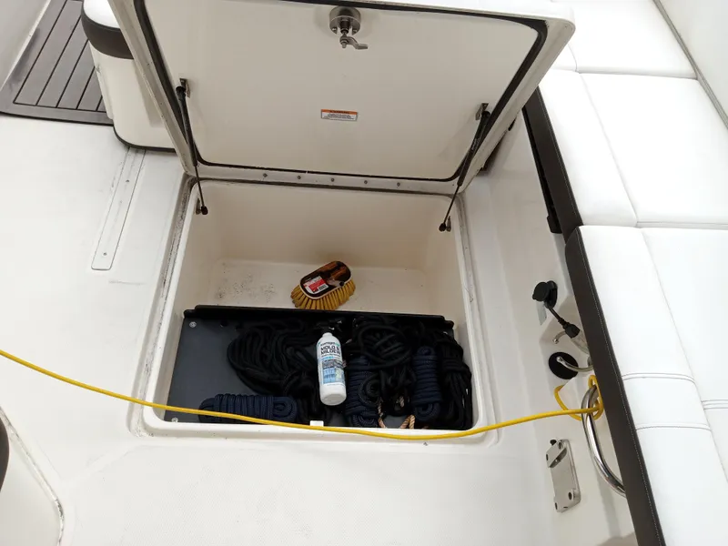 Slide: The Image of Open storage compartment on 2022 Sea Ray SDX 250 Outboard boat with ropes and supplies. - 38