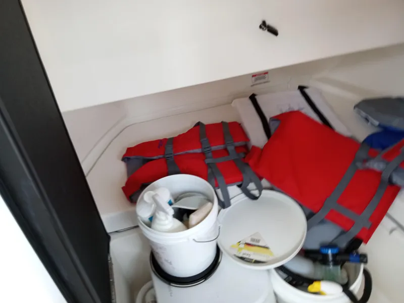 Slide: The Image of Storage compartment in 2022 Sea Ray SDX 250 Outboard with life jackets and supplies. - 39