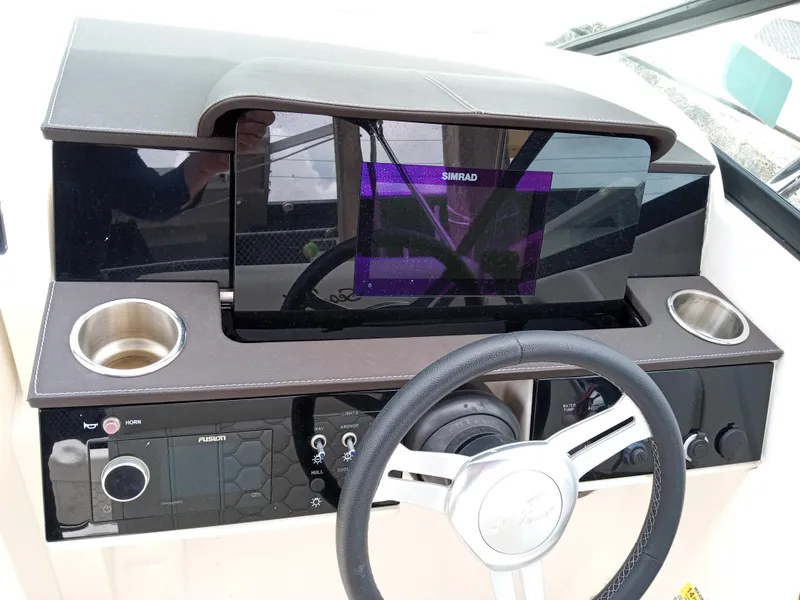 Slide: The Image of 2022 Sea Ray SDX 250 Outboard dashboard with steering wheel and navigation display. - 4