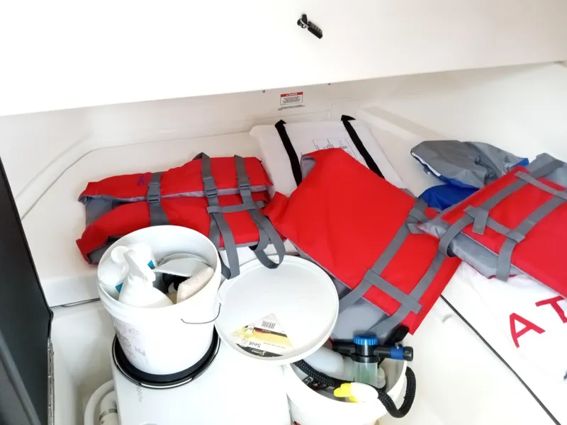Slide: The Image of Storage compartment of 2022 Sea Ray SDX 250 Outboard with life jackets and cleaning supplies. - 40