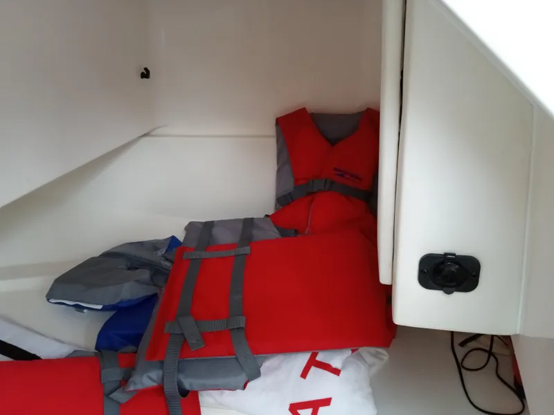 Slide: The Image of Red life jackets stored in a 2022 Sea Ray SDX 250 Outboard boat compartment. - 41