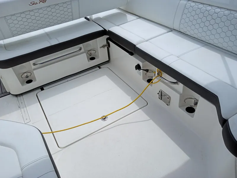Slide: The Image of 2022 Sea Ray SDX 250 Outboard interior seating with storage and utility connections. - 8