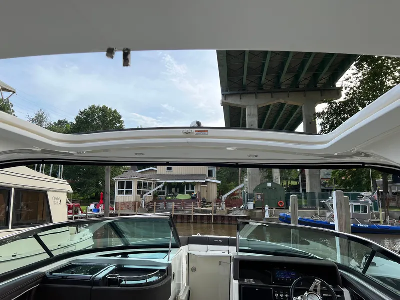 Slide: The Image of 2016 Sea Ray 350 SLX boat interior under a bridge, with waterfront view. - 4
