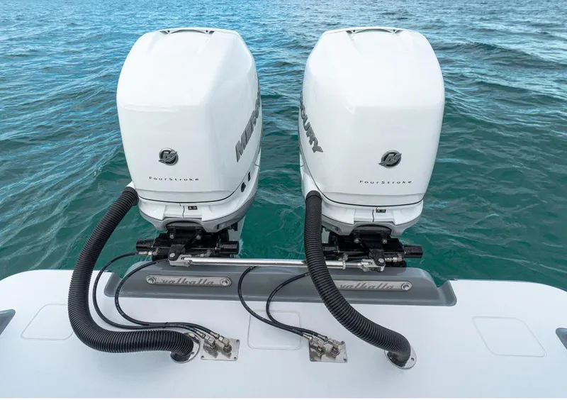 Slide: The Image of Twin Mercury outboard engines on a 2025 Valhalla Boatworks 33, floating on clear blue water. - 4