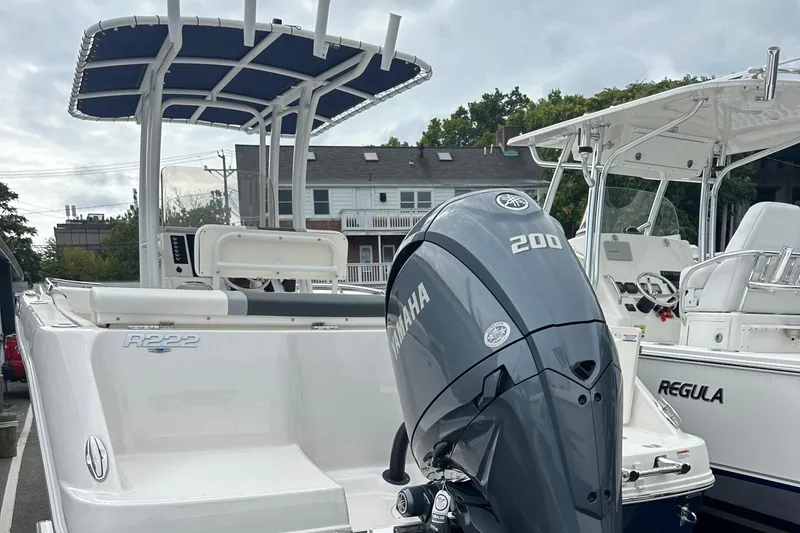 Slide: The Image of 2025 Robalo R222 Center Console boat with Yamaha 200 engine, docked outdoors. - 4