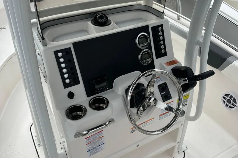 Slide: The Image of 2025 Robalo R222 Center Console boat dashboard with steering wheel and controls. - 7