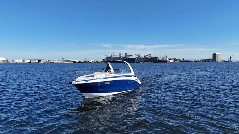 Slide: The Image of 2020 Crownline 264 CR boat on open water with industrial background. - 0