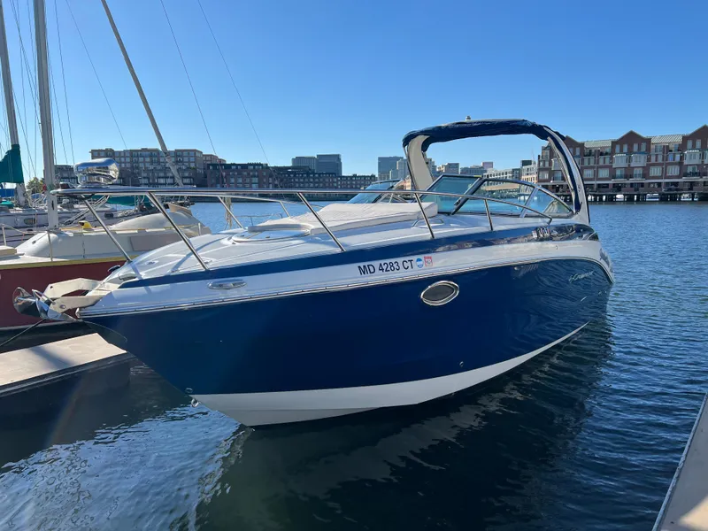 Slide: The Image of 2020 Crownline 264 CR boat docked in marina, clear blue sky background. - 1