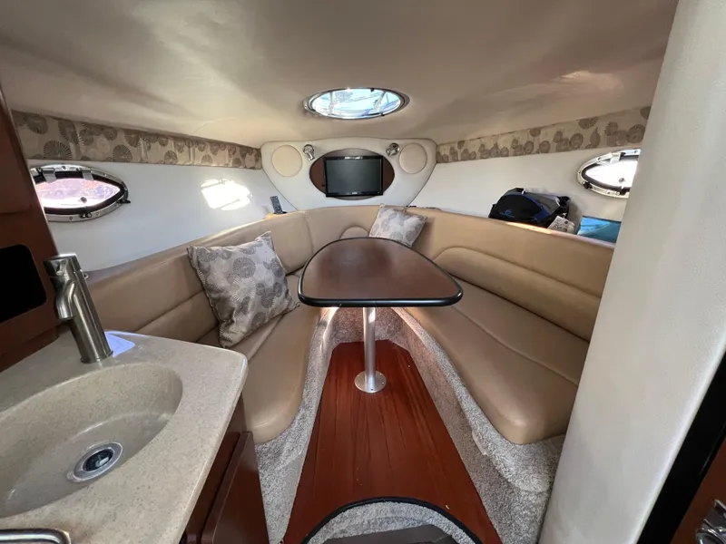 Slide: The Image of 2020 Crownline 264 CR cabin interior with seating, table, and sink. - 29