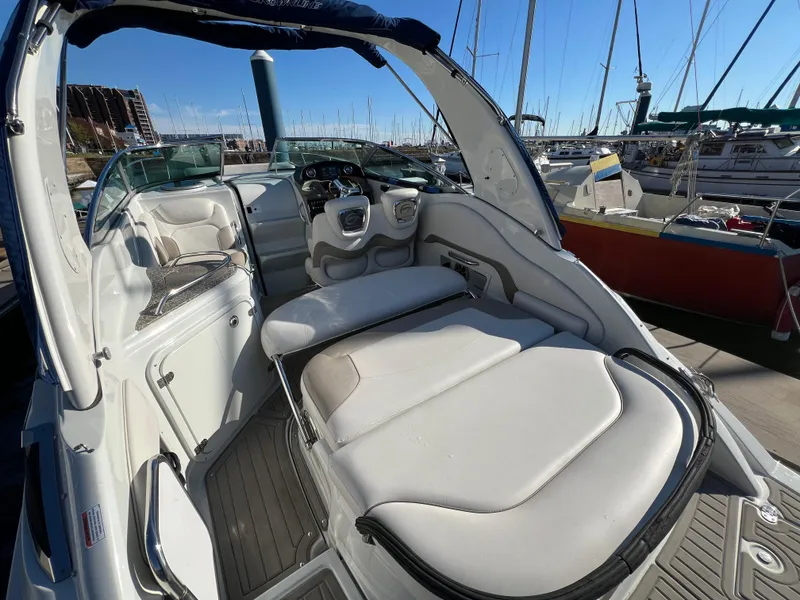 Slide: The Image of 2020 Crownline 264 CR boat interior with seating, docked at marina. - 7