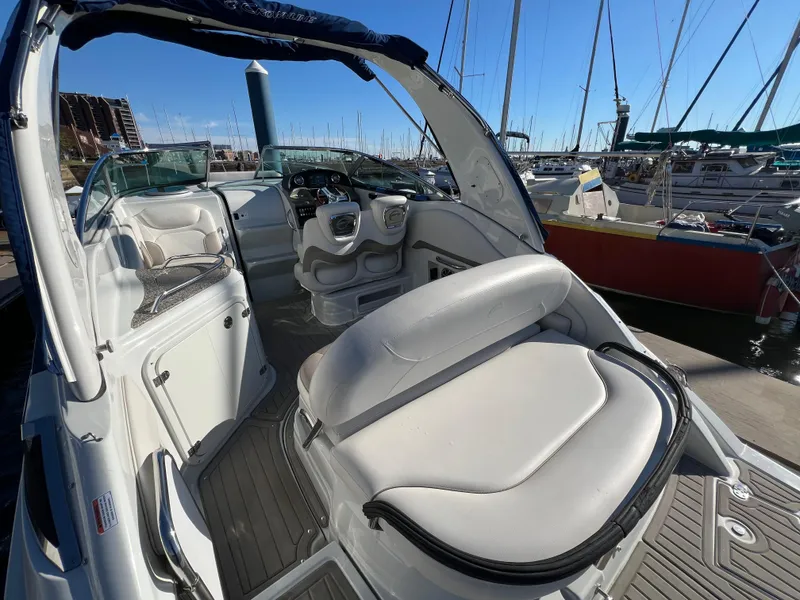 Slide: The Image of 2020 Crownline 264 CR boat interior at marina, featuring sleek seating and modern controls. - 8