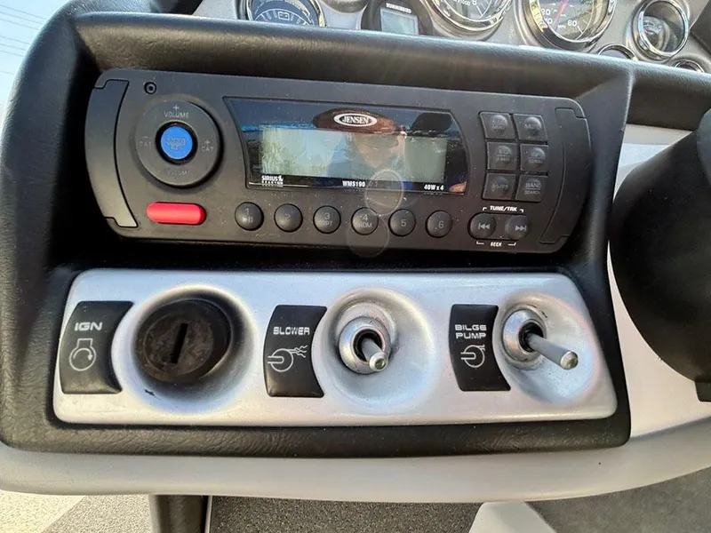 Slide: The Image of Control panel of a 2010 Bayliner 215 BR boat with stereo and switches. - 12