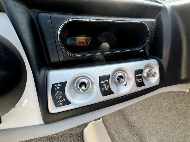 Slide: The Image of Dashboard controls of a 2010 Bayliner 215 BR boat, featuring switches and an empty compartment. - 13