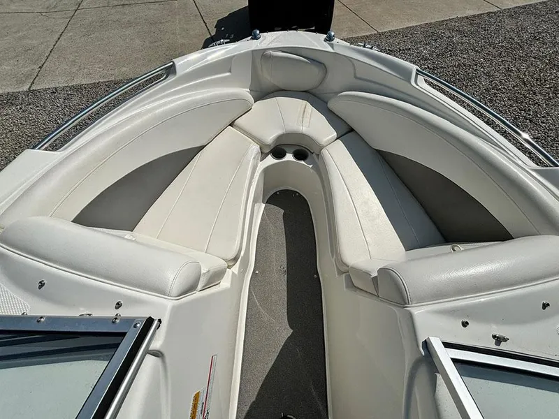 Slide: The Image of 2010 Bayliner 215 BR boat interior with white cushioned seating. - 16