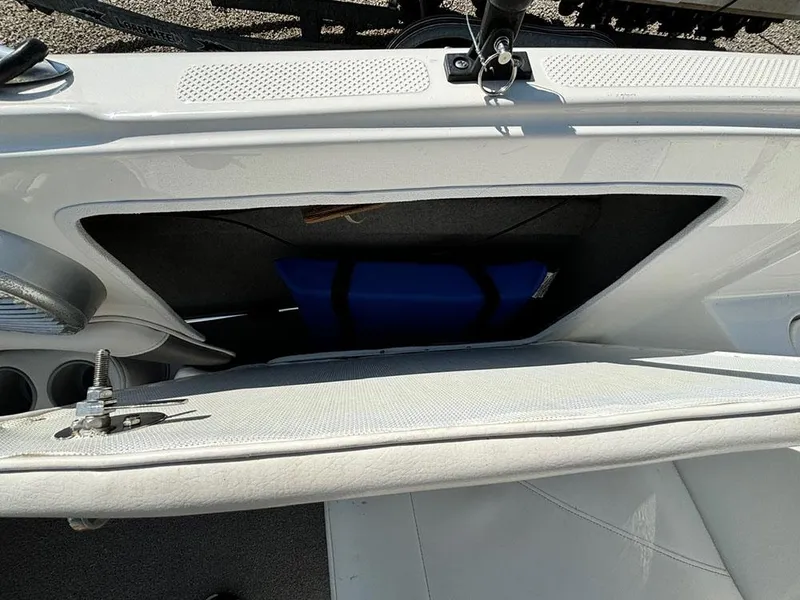 Slide: The Image of 2010 Bayliner 215 BR boat storage compartment with blue item inside. - 18