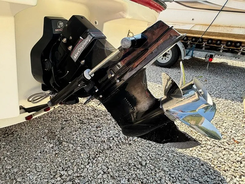 Slide: The Image of 2010 Bayliner 215 BR boat with MerCruiser outdrive on gravel surface. - 22