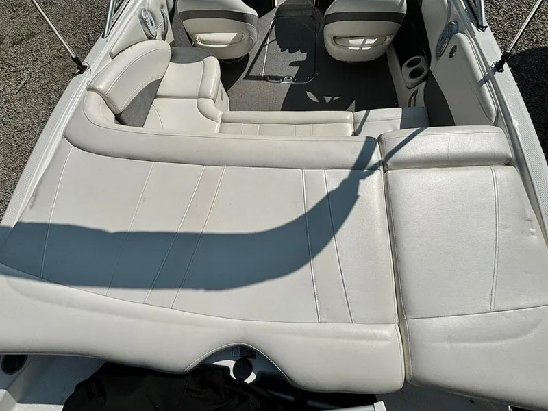 Slide: The Image of 2010 Bayliner 215 BR boat interior with white leather seating and spacious layout. - 5