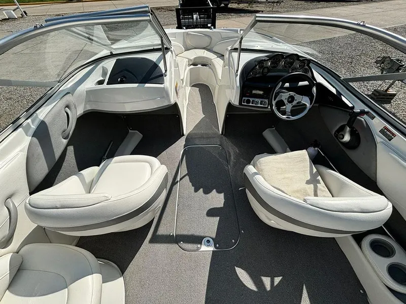 Slide: The Image of 2010 Bayliner 215 BR boat interior with white seating and steering console. - 9