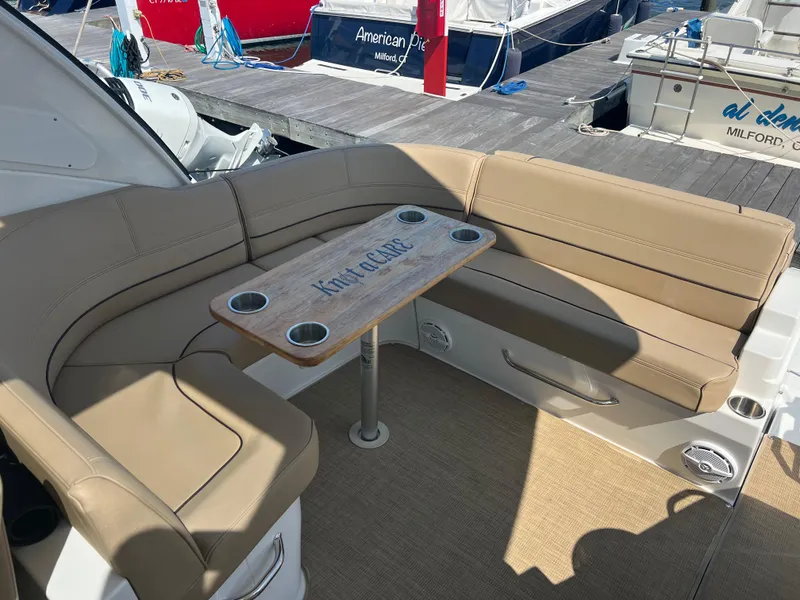 Slide: The Image of 2015 Cruisers Yachts 350 Express seating area with table, docked at marina. - 12