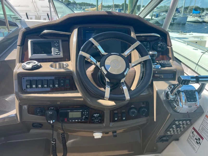 Slide: The Image of 2015 Cruisers Yachts 350 Express helm with steering wheel and control panel. - 14
