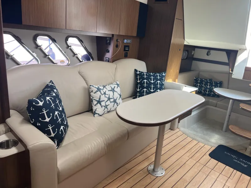 Slide: The Image of Interior of 2015 Cruisers Yachts 350 Express with nautical-themed cushions and wooden flooring. - 16