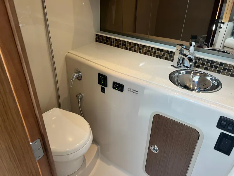 Slide: The Image of 2015 Cruisers Yachts 350 Express bathroom with modern sink and toilet. - 17