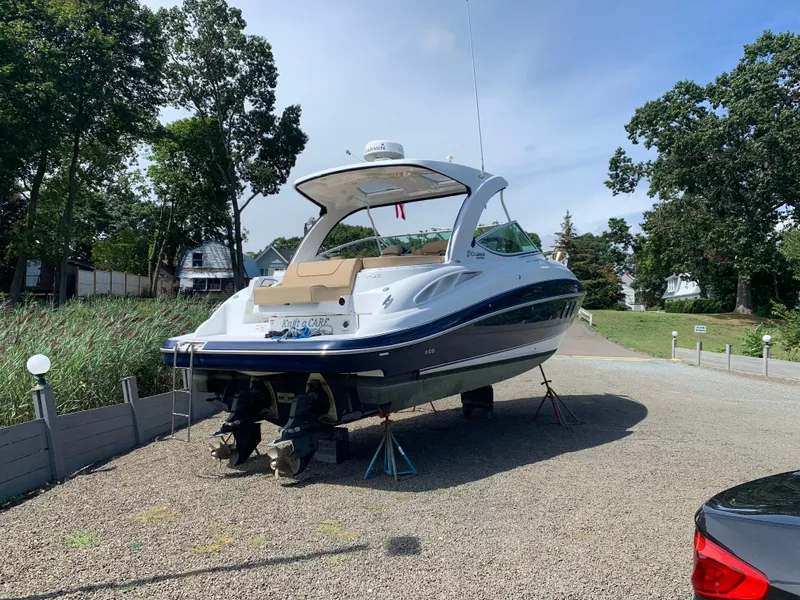 Slide: The Image of 2015 Cruisers Yachts 350 Express on dry land, surrounded by trees. - 2