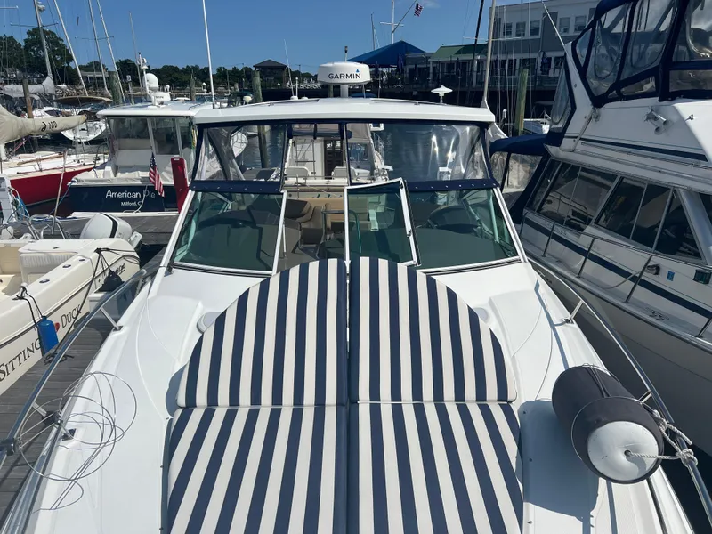 Slide: The Image of 2015 Cruisers Yachts 350 Express docked, featuring striped sun pads and sleek design. - 7