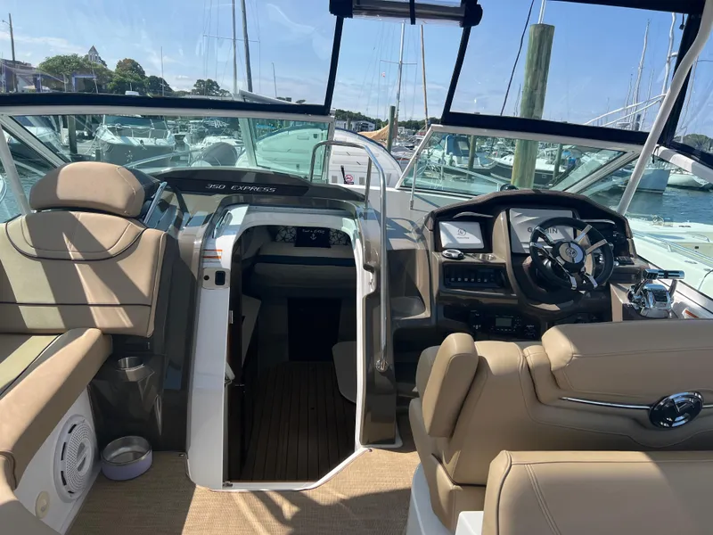 Slide: The Image of 2015 Cruisers Yachts 350 Express cockpit with beige seating and modern controls. - 8