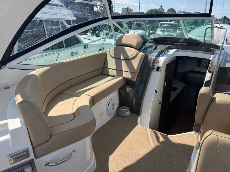 Slide: The Image of 2015 Cruisers Yachts 350 Express interior with beige seating and cabin entrance. - 9