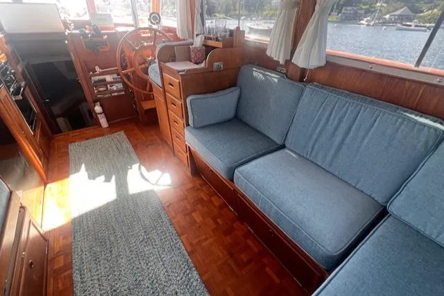 Slide: The Image of Interior of 1980 Grand Banks 32 Flybridge Trawler with blue seating and wooden accents. - 2