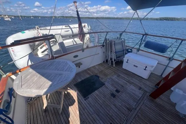 Slide: The Image of 1980 Grand Banks 32 Flybridge Trawler deck with table, chairs, and ocean view. - 20