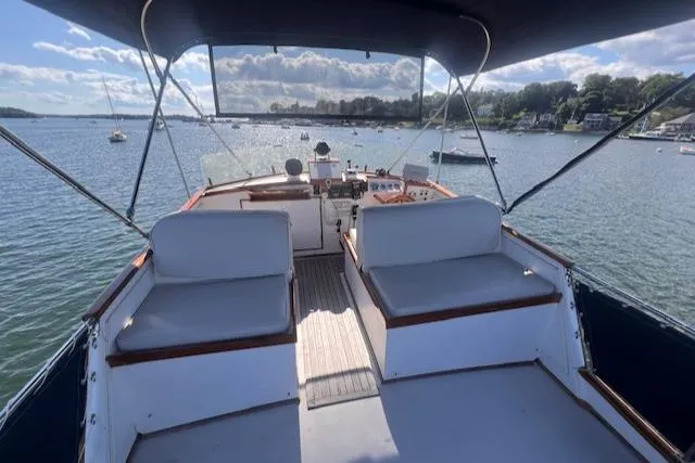 Slide: The Image of 1980 Grand Banks 32 Flybridge Trawler, spacious deck view, overlooking serene waters and distant shoreline. - 22