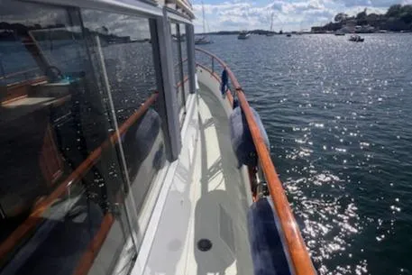 Slide: The Image of 1980 Grand Banks 32 Flybridge Trawler on water, showcasing deck and scenic view. - 28