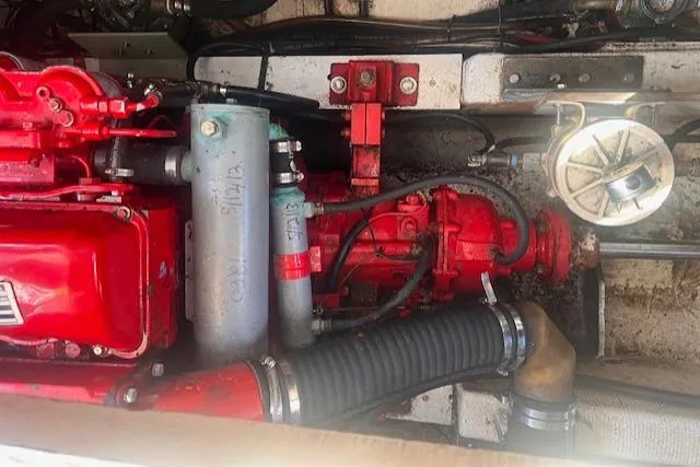 Slide: The Image of Engine compartment of a 1980 Grand Banks 32 Flybridge Trawler, showcasing red mechanical components. - 29