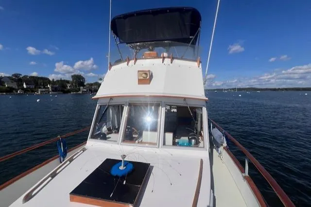 Slide: The Image of 1980 Grand Banks 32 Flybridge Trawler on calm water under clear blue sky. - 30
