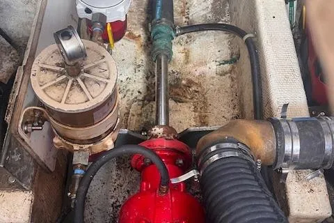 Slide: The Image of Engine compartment of 1980 Grand Banks 32 Flybridge Trawler, showing mechanical components and hoses. - 36