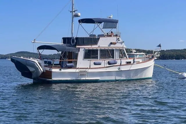 Slide: The Image of 1980 Grand Banks 32 Flybridge Trawler on calm water, featuring classic design and flybridge. - 38