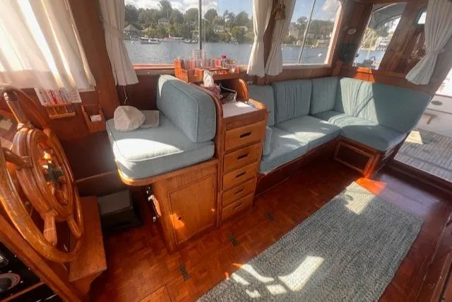Slide: The Image of Interior of 1980 Grand Banks 32 Flybridge Trawler with wooden helm and blue seating. - 4