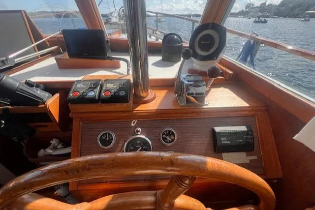 Slide: The Image of 1980 Grand Banks 32 Flybridge Trawler helm with wooden steering wheel and navigational instruments. - 6
