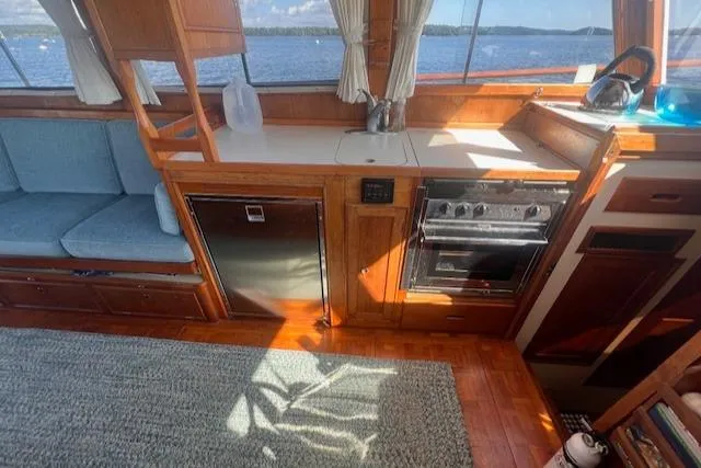 Slide: The Image of 1980 Grand Banks 32 Flybridge Trawler interior with kitchen and seating area. - 7