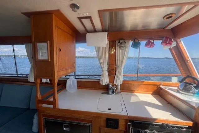Slide: The Image of Interior of 1980 Grand Banks 32 Flybridge Trawler with wooden cabinetry and ocean view. - 8