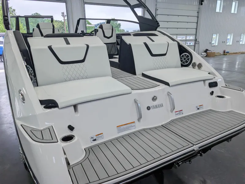 Slide: The Image of 2025 Yamaha Boats 222SE interior with sleek seating and modern design in a showroom. - 10