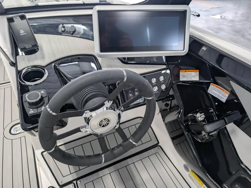 Slide: The Image of 2025 Yamaha Boats 222SE helm with steering wheel, touchscreen, and control panel. - 23