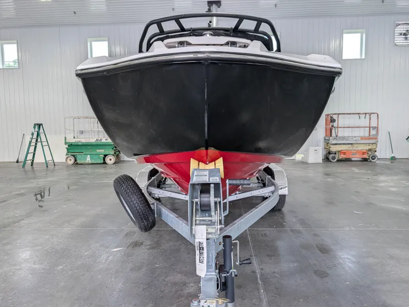 Slide: The Image of 2025 Yamaha Boats 222SE on trailer in a spacious indoor facility. - 4